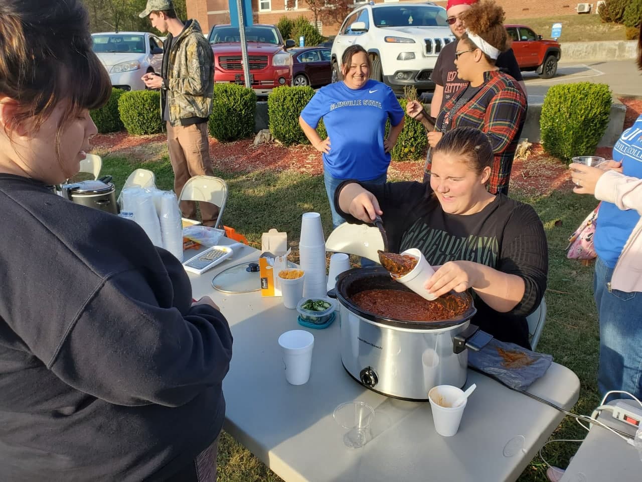 NAfME at the 2019 Glenville State College Chili Contest College students serving chili into styrofoam cups in the outdoors